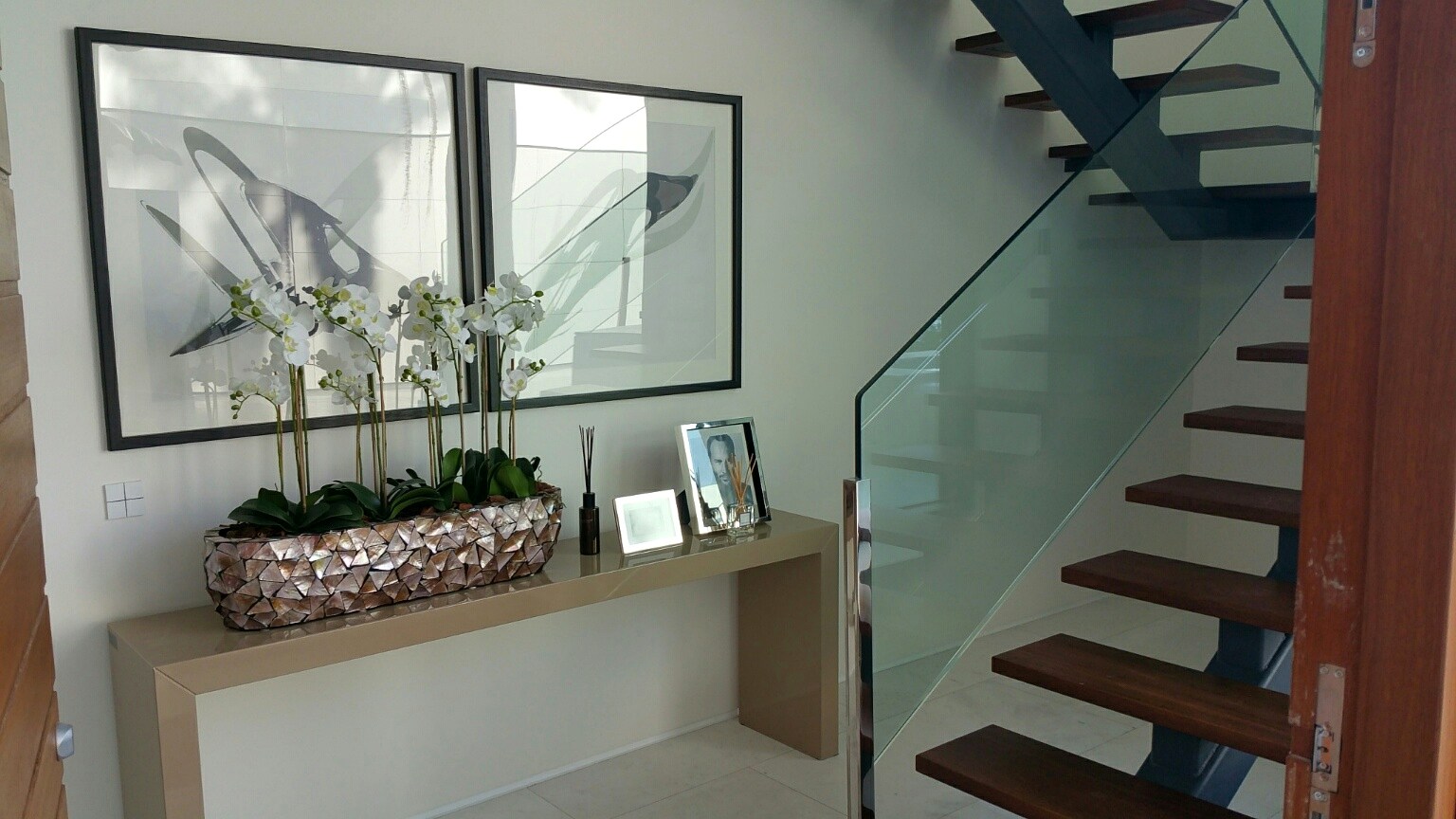 Vestíbulo con escalera y pulsadores Basalte Sentido en acabado blanco mate en vivienda de Altea Hills.