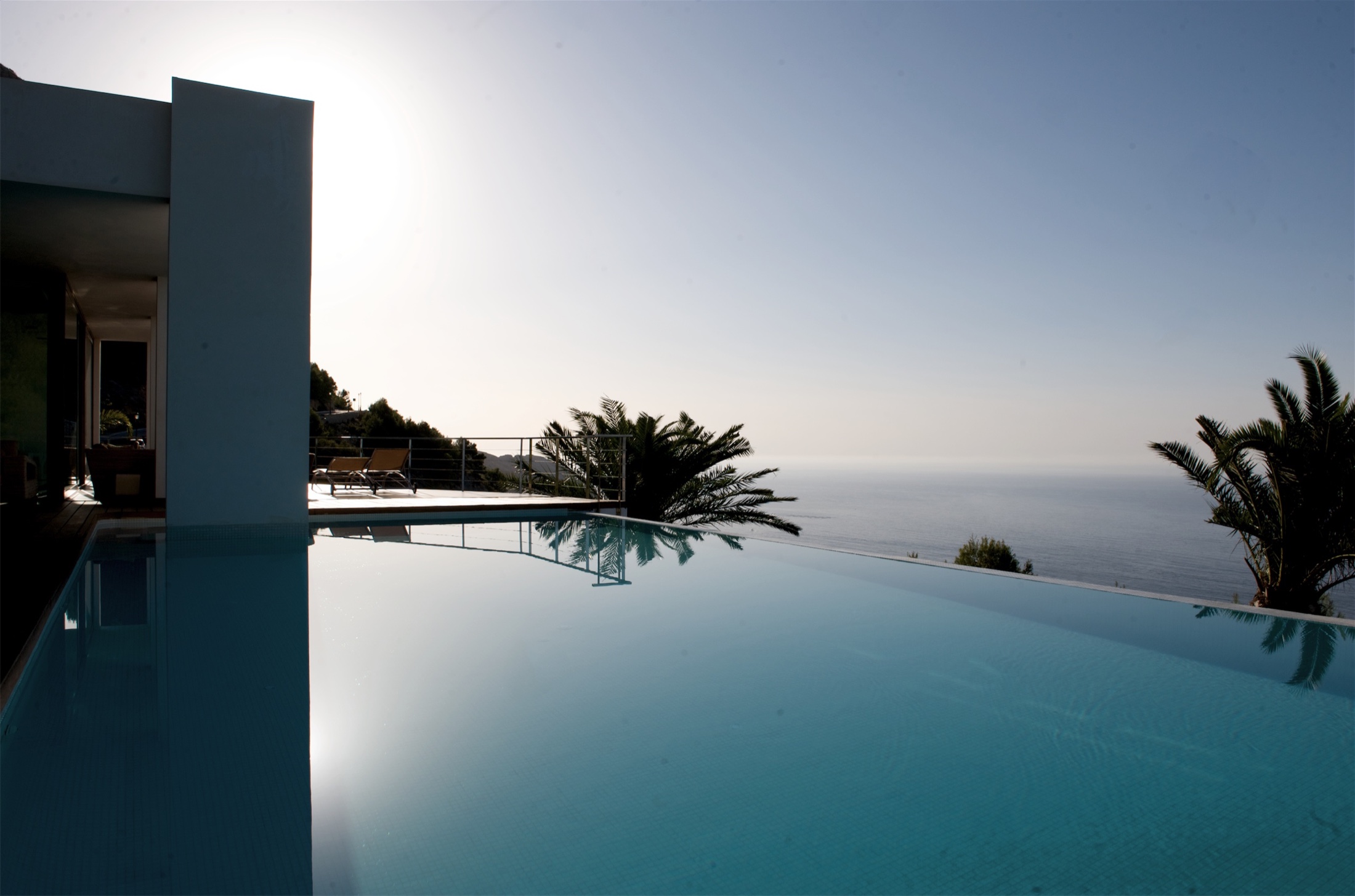 Piscina infinita al atardecer en vivienda integrada de Altea Hills.